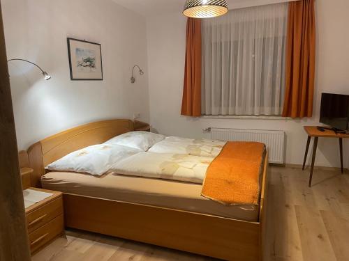 ein Schlafzimmer mit einem Bett in einem Zimmer in der Unterkunft Ferienwohnungen Rasinger in Schiefling am See