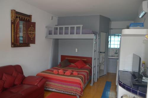 ein Schlafzimmer mit einem Etagenbett und einem Sofa in der Unterkunft Studio Tishka in Oualidia