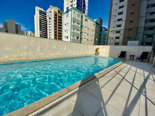 uma piscina no topo de um edifício com edifícios altos em Cobertura Duplex Encantadora com jacuzzi Privativa Vista mar em Vila Velha