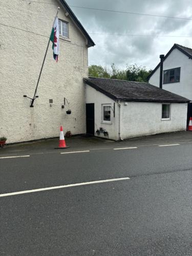 a building with a flag on the side of it at Dolgoch Mill House Annexe in Llanfair Caereinion
