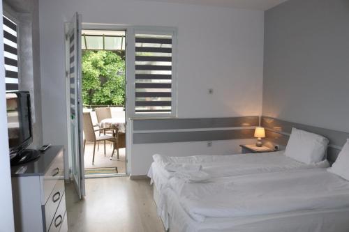 ヴェリングラードにあるSaint Maria Guest Houseのベッドルーム1室(ベッド2台、テレビ、パティオ付)