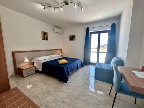 ein Schlafzimmer mit einem blauen Bett und einem Fenster in der Unterkunft Pasquale's House in Sant'Agnello