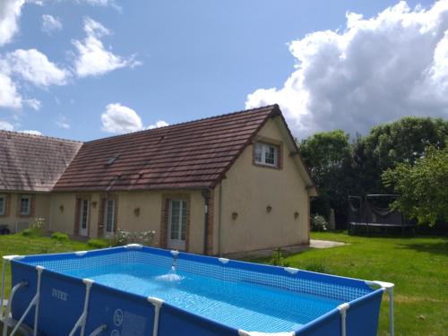 une maison avec une piscine dans la cour dans l'établissement Gîte le beaujouas, à Thiberville