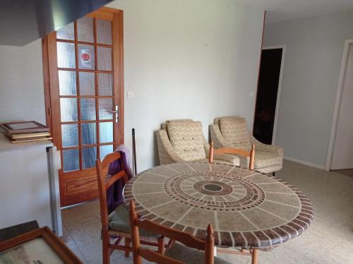 un salon avec une table et des chaises et une salle à manger dans l'établissement Maison d'Aline, à Pléguien