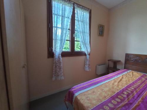 une chambre avec un lit et une fenêtre dans l'établissement Maison d'Aline, à Pléguien