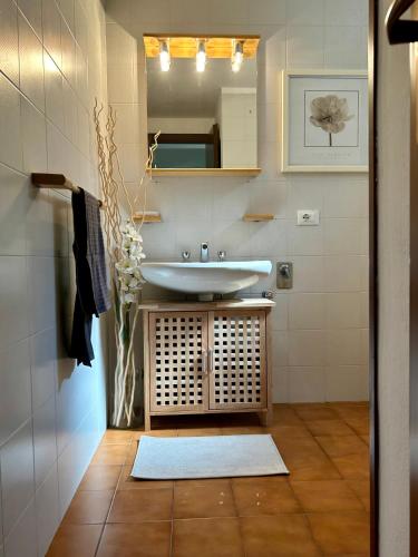 a bathroom with a sink and a mirror at Bellagio Neighbor Apartment in Limonta