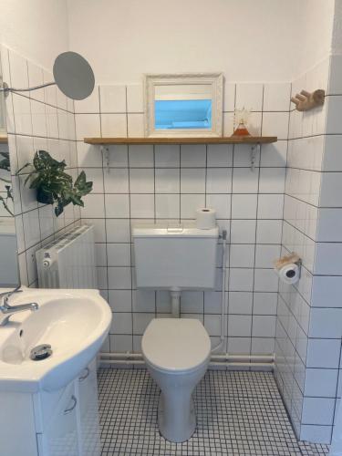 y baño con aseo blanco y lavamanos. en WARMEHUISJE.NL en Warmenhuizen