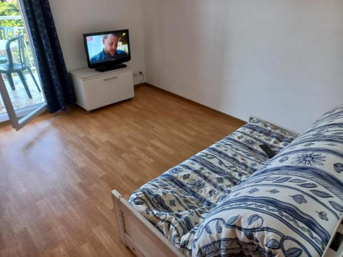 a bedroom with a bed and a tv in a room at Appartement Le Verdon sur mer in Le Verdon-sur-Mer