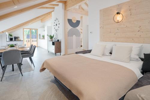 a bedroom with a large bed and a dining room at FENJOY Ferienapartments am Chiemsee mit Bergblick in Bernau am Chiemsee