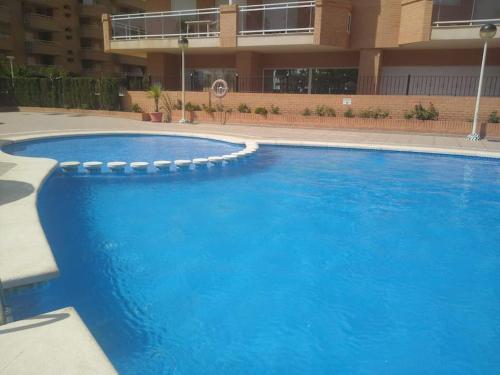 a large blue swimming pool in front of a building at Las mejores vistas de Oropesa in El Borseral
