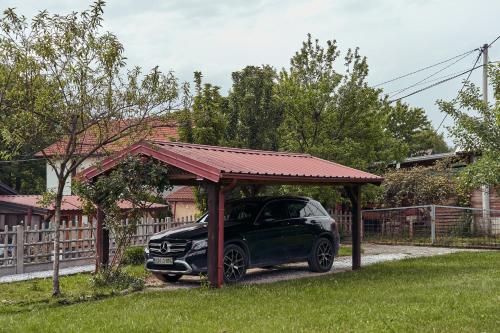 a car parked under a gazebo in a yard at Nanki's Residence in Visoko