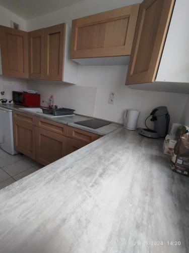 a kitchen with wooden cabinets and a counter top at Appartement à proximité de disney de val d europe in Montévrain