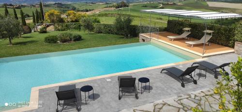 an overhead view of a swimming pool with chairs and a table at Cintoia, Tuscany Beautiful villa with private pool in Santa Luce