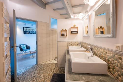łazienka z 2 umywalkami i lustrem w obiekcie Chez la fille de l éclusier w mieście Castelnaudary