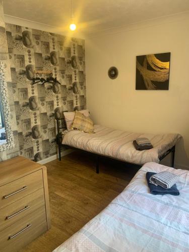 a bedroom with two beds and a dresser in it at Kings Lynn 1 in Kings Lynn