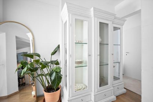 un armario blanco con espejo y una planta en City Vibe Villa with pool, en Split