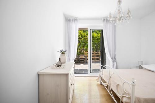 Habitación blanca con cama y lámpara de araña. en City Vibe Villa with pool, en Split