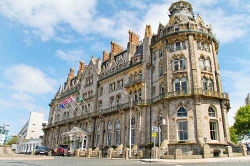 ein großes Steingebäude mit einem Turm in der Unterkunft Duke Of Cornwall Hotel in Plymouth