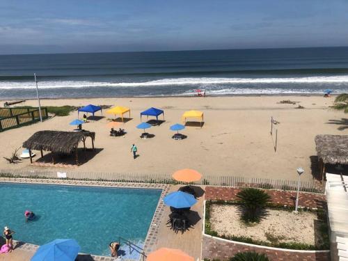 a view of a beach with umbrellas and a swimming pool at Dept en Playas Sol Arena Mar y Piscina in Playas