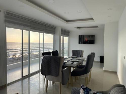 a dining room with a table and chairs and the ocean at Dept en Playas Sol Arena Mar y Piscina in Playas