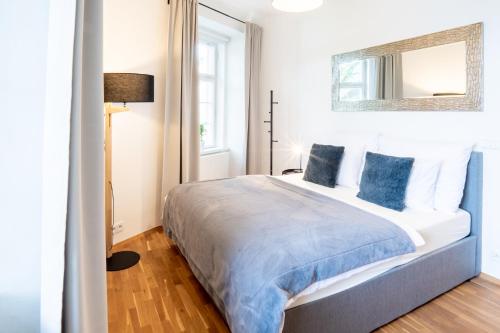 ein Schlafzimmer mit einem großen Bett und blauen Kissen in der Unterkunft River View Apartment in Prag