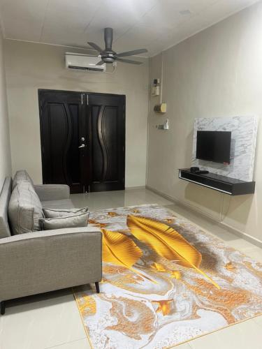 a living room with a couch and a large rug at Adhwa Homestay in Kampong Bukit Katil