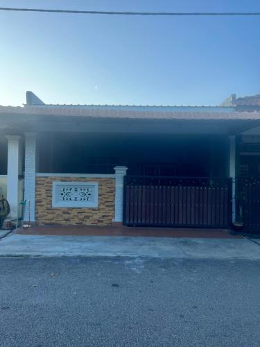 a house with a fence in front of it at Adhwa Homestay in Kampong Bukit Katil