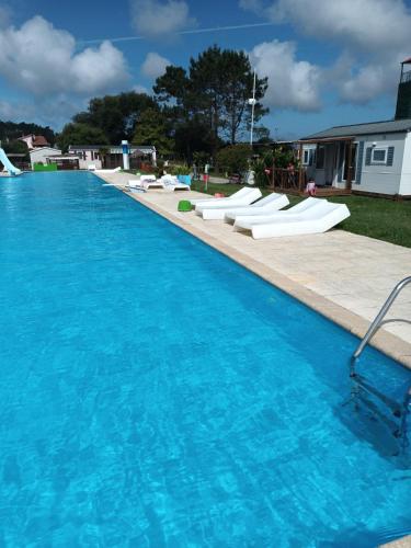a large swimming pool with blue water in a yard at Slow M'Ocean Villa in Pataias