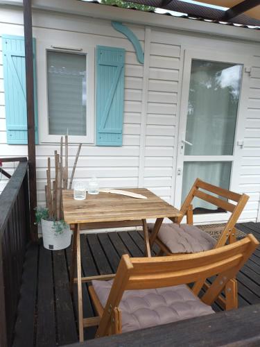 a wooden table and two chairs on a deck at Slow M'Ocean Villa in Pataias