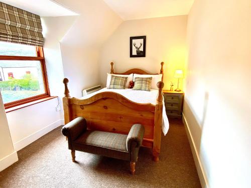 a bedroom with a bed and a chair and a window at Bruachdryne Braemar Accommodation in Braemar