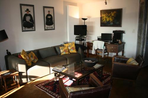 un soggiorno con divano e tavolo di B&B De Mansarde a Diest