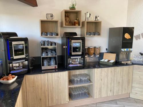 een aanrecht met verschillende koffiezetapparaten bij Hôtel Spa L'Ermitage in Les Salles-sur-Verdon