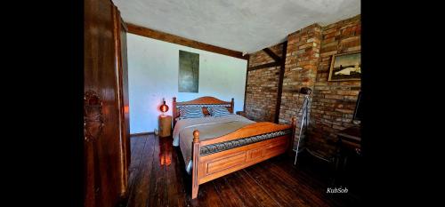 1 dormitorio con cama y pared de ladrillo en Earthship Mierzeszyn en Mierzeszyn
