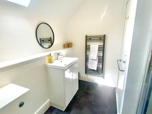 a white bathroom with a sink and a mirror at Bruachdryne Braemar Accommodation in Braemar