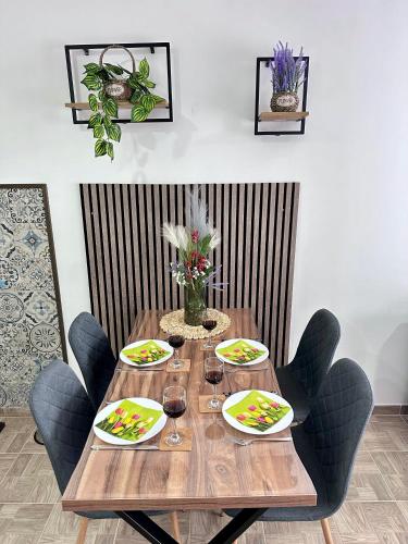 a wooden table with plates of food and wine glasses at Kristi Lux NEW 1-bedroom apartment with Pool, Balcony and FREE Parking in Veliko Gradište