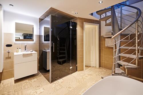 a bathroom with a shower and a sink and a mirror at Goldmädchen 93 - Beach Studio in Häven