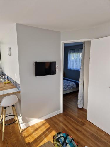 una camera da letto con una parete e una TV di Logement T2 neuf-évasion en Corrèze a Ligneyrac