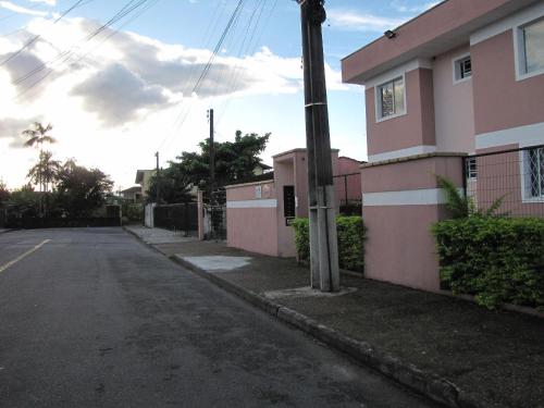 Une rue vide à côté d'un bâtiment rose dans l'établissement RCM Vilas - STUDIO n18 Deluxe, à Joinville