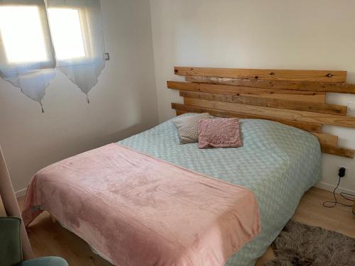 a bedroom with a bed with a wooden headboard at Gite cœur du village de Clérac in Clérac