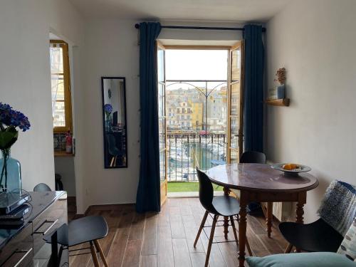 un salon avec une table et une grande fenêtre dans l'établissement appartement sur le vieux port, à Bastia