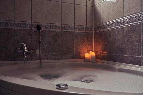 a large bath tub with two candles in it at Nanki's Residence in Visoko