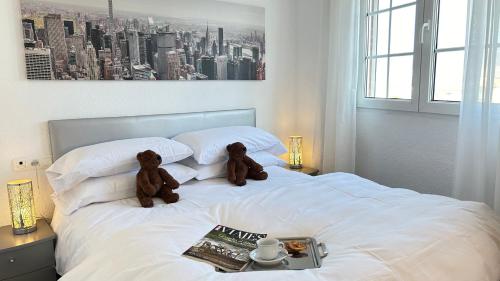 two teddy bears sitting on top of a bed at Íberos Royal in La Zubia