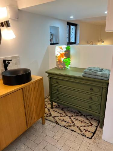 a bathroom with a green dresser and a sink at La maison des artistes in Savigny-sur-Orge