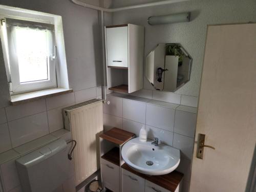 a small bathroom with a sink and a window at Ferienwohnung Lux in Markische Heide
