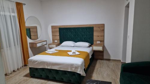 a bedroom with a bed with two towels on it at Apartmani Enydoo in Ulcinj