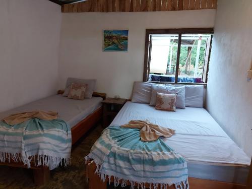 a bedroom with two beds and a window at Anez Cabin'S in Cabuya