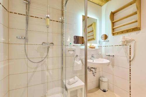 a bathroom with a shower and a sink at Hotel Waldgasthof Buchenhain in Baierbrunn