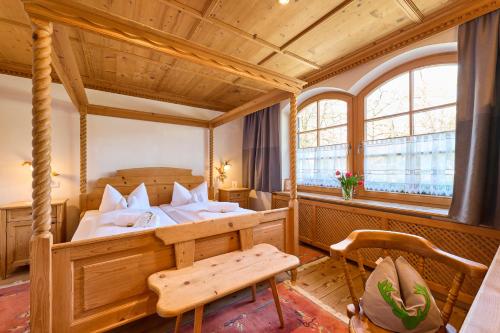 a bedroom with a bed and a table in a room at Hotel Waldgasthof Buchenhain in Baierbrunn