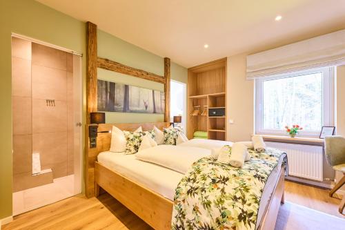 a bedroom with a bed and a walk in shower at Hotel Waldgasthof Buchenhain in Baierbrunn