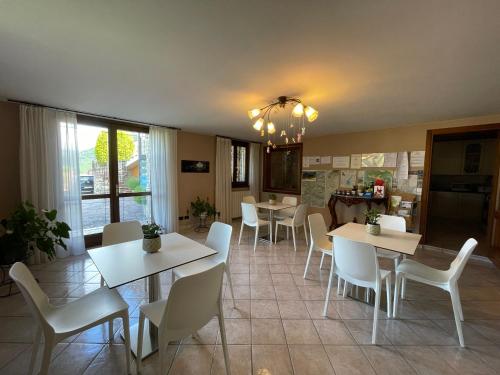 uma sala de jantar com mesas brancas e cadeiras brancas em Appartamenti Isola Verde em Villa